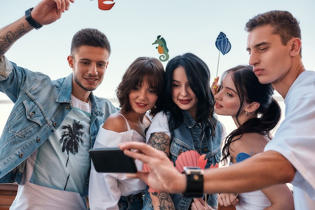 Groupe de moments heureux d'amis heureux faisant un selfie tout en faisant la fête sur le toit