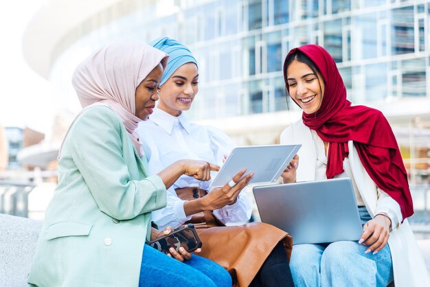 Groupe multiethnique de filles musulmanes portant des vêtements décontractés et des liens traditionnels avec le hijab et s'amusant à l'extérieur - 3 jeunes filles arabes