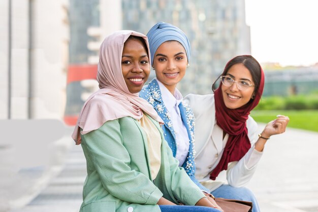 groupe multiethnique de filles musulmanes portant des vêtements décontractés et des liens traditionnels avec le hijab