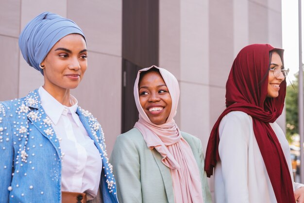 groupe multiethnique de filles musulmanes portant des vêtements décontractés et des liens traditionnels avec le hijab