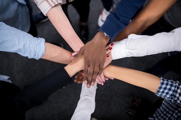 Groupe multiethnique de jeunes gens d'affaires célébrant le succès sur leur lieu de travail dans le succès du bureau de démarrage et le concept gagnant