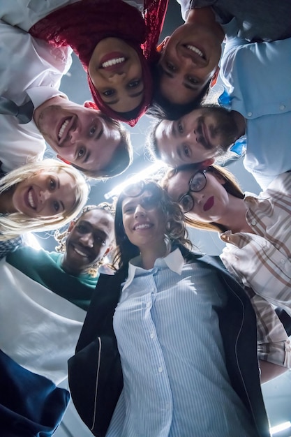 Groupe multiethnique de jeunes gens d'affaires célébrant le succès sur leur lieu de travail dans le succès du bureau de démarrage et le concept gagnant