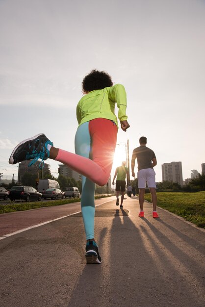 groupe multiethnique de jeunes sur le jogging beau matin alors que le soleil se lève dans les rues de la ville