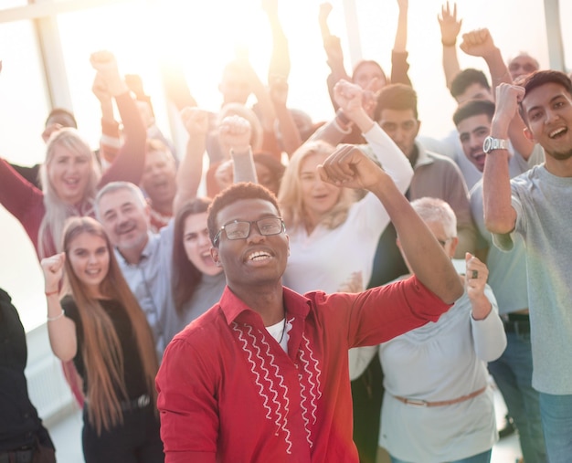 Groupe multinational de personnes heureuses debout avec leurs mains en l'air