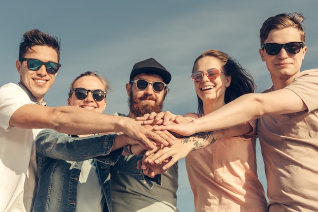 Groupe multiracial d'amis avec les mains sur la pile