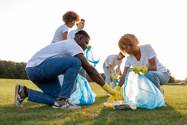 un groupe multiracial de bénévoles avec des sacs à ordures recueillent des ordures et du plastique