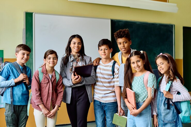 Photo un groupe multiracial d'écoliers avec leur professeur dans la salle de classe regardant la caméra.