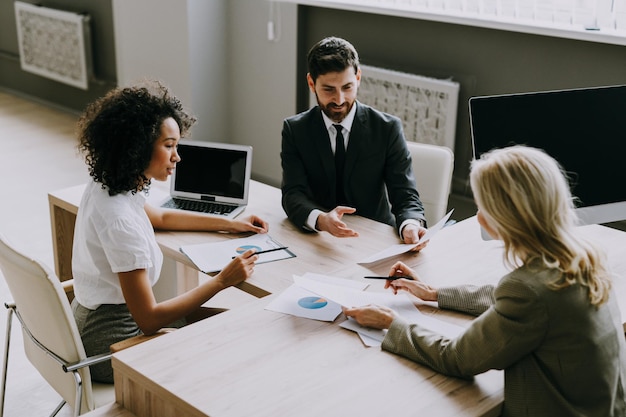 Groupe multiracial d'hommes d'affaires avec une robe élégante assis au bureau de l'ordinateur au bureau