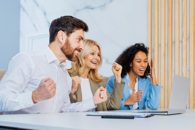 Groupe multiracial d'hommes d'affaires avec une robe élégante assis au bureau de l'ordinateur au bureau