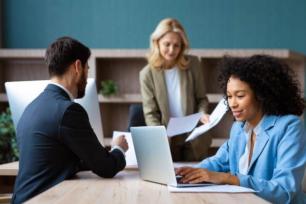 Groupe multiracial d'hommes d'affaires avec une robe élégante assis au bureau de l'ordinateur au bureau