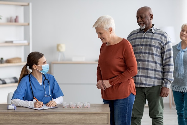 Groupe multiracial de personnes âgées prenant des pilules le matin