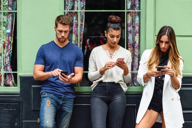 Groupe multiracial de personnes regardant le téléphone intelligent