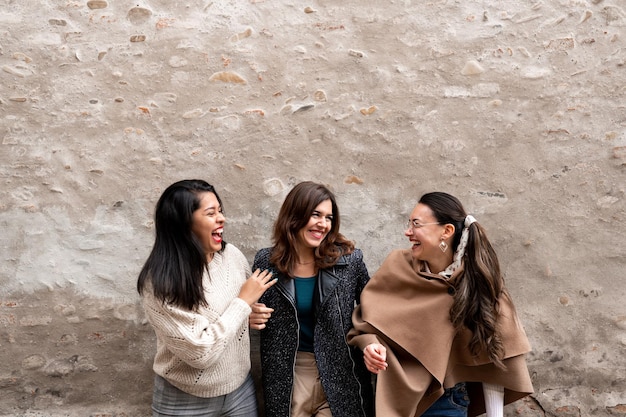 Groupe multiracial de trois femmes heureuses élégantes qui rient. Concept d'amitié et de convivialité.