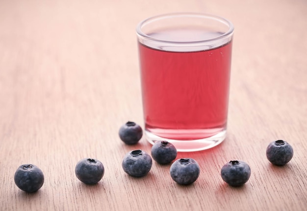 Groupe de myrtilles fraîches avec du jus dans un verre