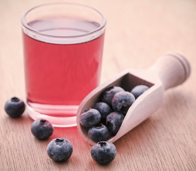 Groupe de myrtilles fraîches avec du jus dans un verre