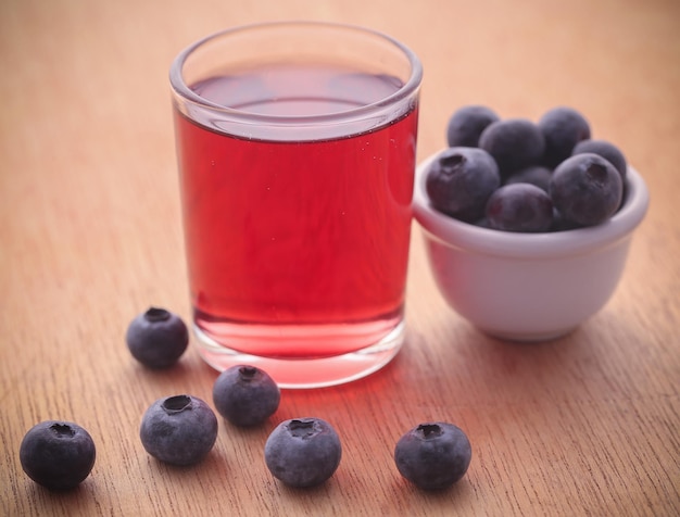 Groupe de myrtilles fraîches avec du jus dans un verre