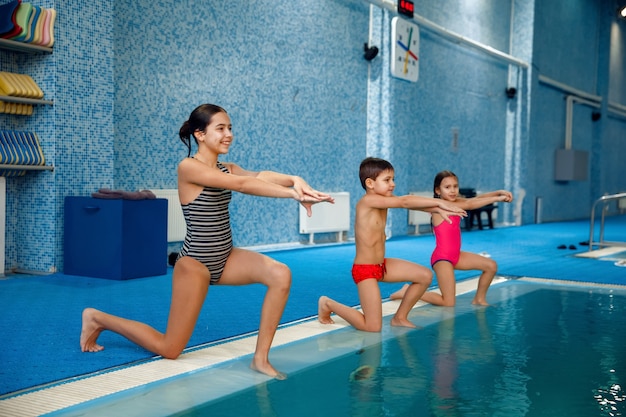 Groupe de natation enfants, entraînement au bord de la piscine.