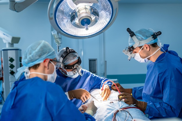 Groupe de neurochirurgiens en salle d'opération avec équipement chirurgical. Opération à l'hôpital. Formation médicale, mise au point sélective.