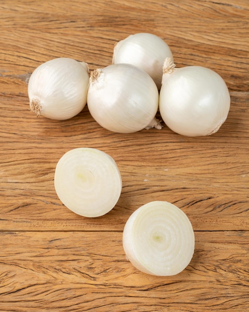 Un groupe d'oignons blancs sur une table en bois