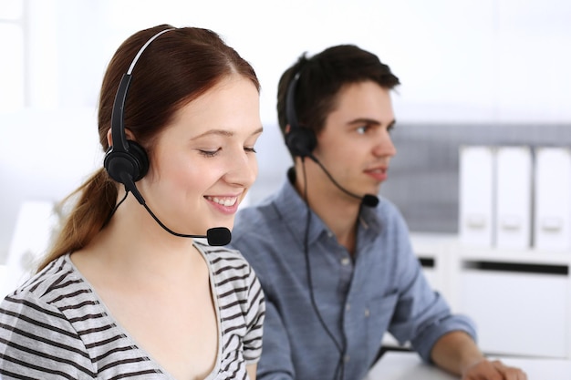 Groupe d'opérateurs au travail Centre d'appel Focus sur la femme réceptionniste dans le casque au service client