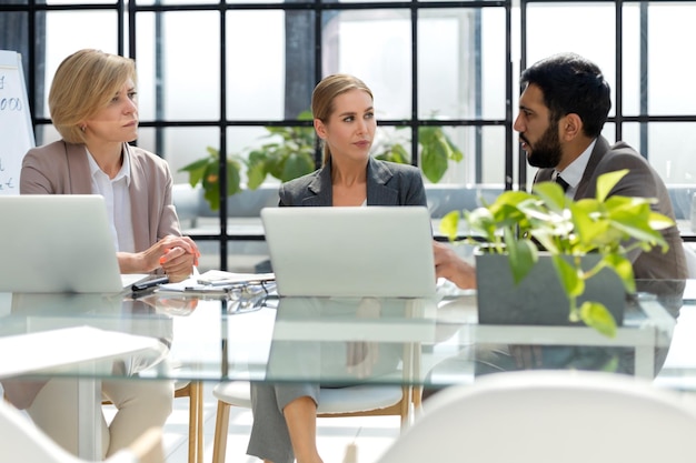 Groupe de partenaires commerciaux discutant d'idées et planifiant le travail au bureau