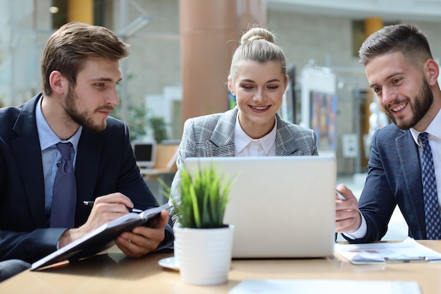 Groupe de partenaires commerciaux discutant des idées et planifiant le travail au bureau.