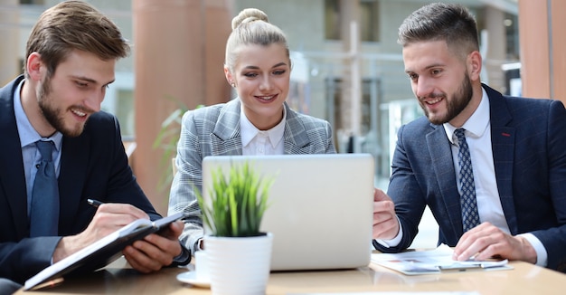 Groupe de partenaires commerciaux discutant des idées et planifiant le travail au bureau.