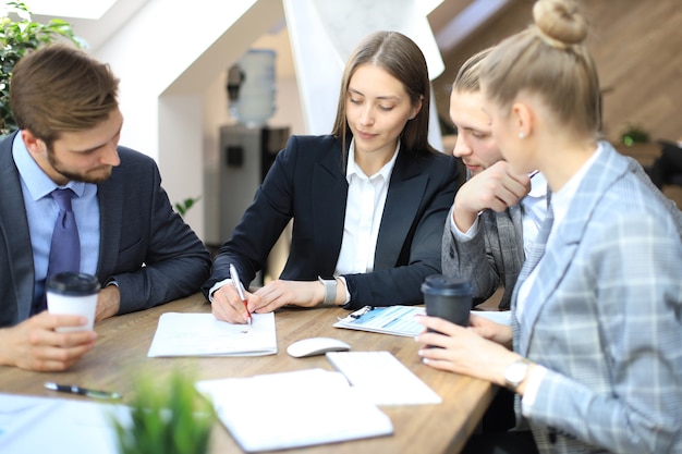 Groupe de partenaires commerciaux discutant de stratégies lors d'une réunion au bureau.