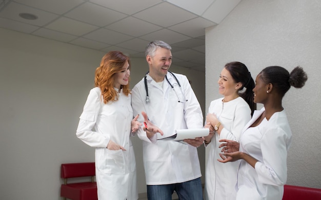 Un groupe de personnel médical communique et rit dans le couloir de la clinique