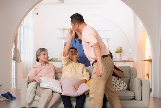 Un groupe de personnes âgées asiatiques et de soignants s'amusent dans la maison de retraite.