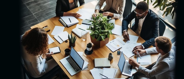 Photo un groupe de personnes assis à une table avec des ordinateurs portables et des papiers dessus