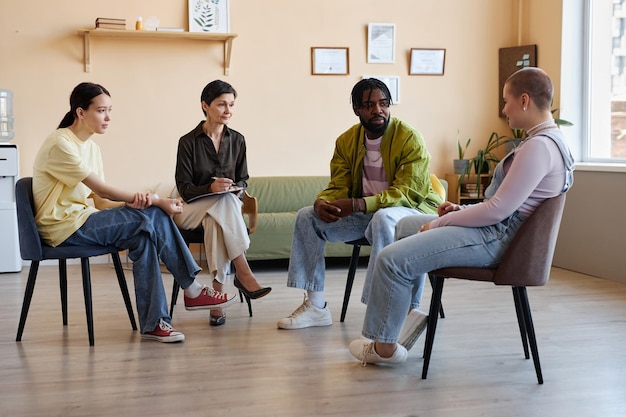 Photo groupe de personnes assises à une session psycho