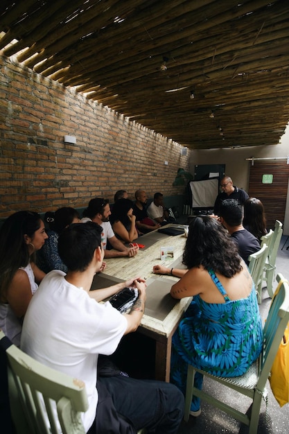 Photo un groupe de personnes assises à une table dans une pièce.