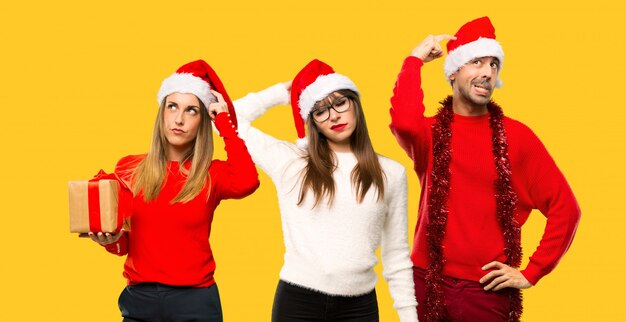 Un groupe de personnes blonde femme habillée pour les vacances de Noël ayant des doutes