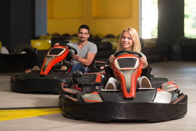 Un groupe de personnes conduit une voiture de kart avec de la vitesse dans une piste de course de terrain de jeu Go Kart est un sport automobile de loisir populaire