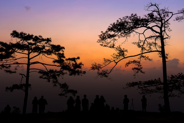 Groupe de personnes debout au coucher du soleil