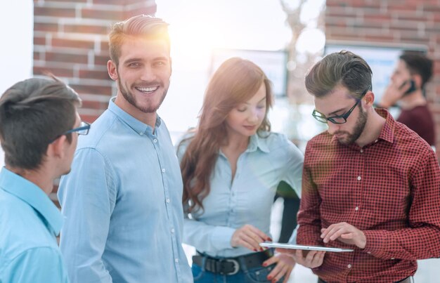 Groupe de personnes discutant de plans d'affaires avec tablette