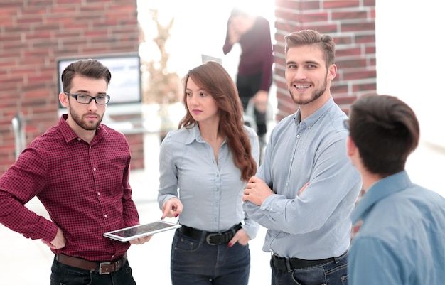 Groupe de personnes discutant de plans d'affaires avec tablette