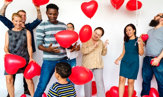 Groupe de personnes divers tenant des ballons coeur