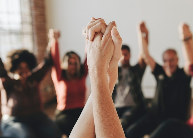 Groupe de personnes diverses tenant les mains en l'air