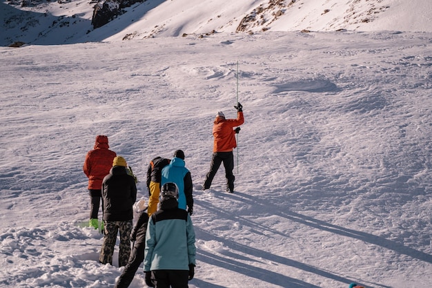 Photo un groupe de personnes est chargé de marcher sur une montagne enneigée