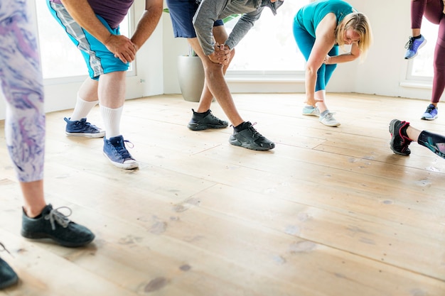 Groupe de personnes faisant des étirements de quadriceps en classe