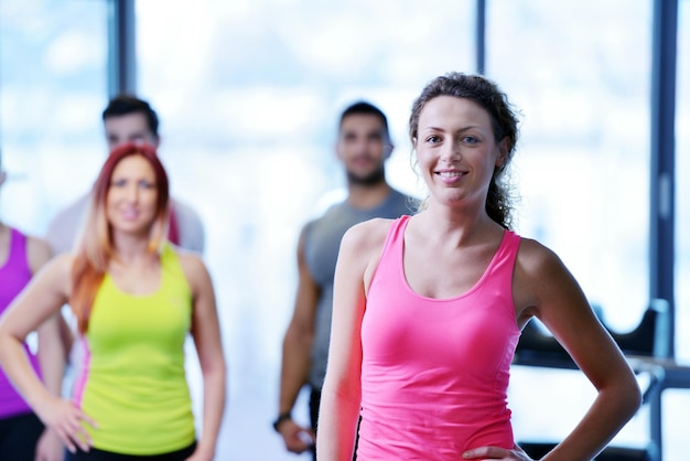 Groupe de personnes faisant de l'exercice au gymnase et s'étirant