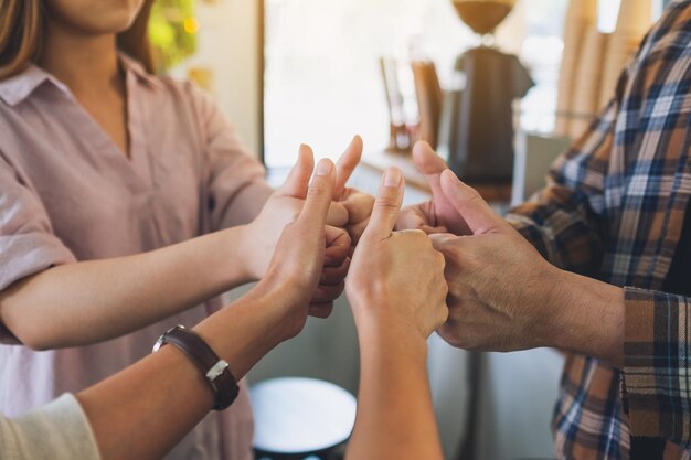 Un groupe de personnes faisant signe de mains pouce vers le haut en cercle