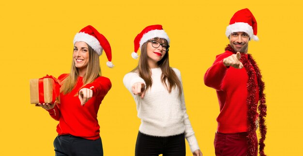 Photo un groupe de personnes une femme blonde habillée pour les vacances de noël pointe le doigt vers vous