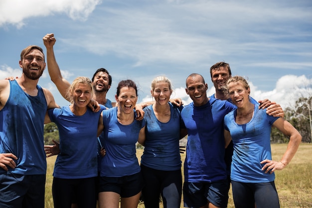 Groupe de personnes en forme posant ensemble dans le camp d'entraînement