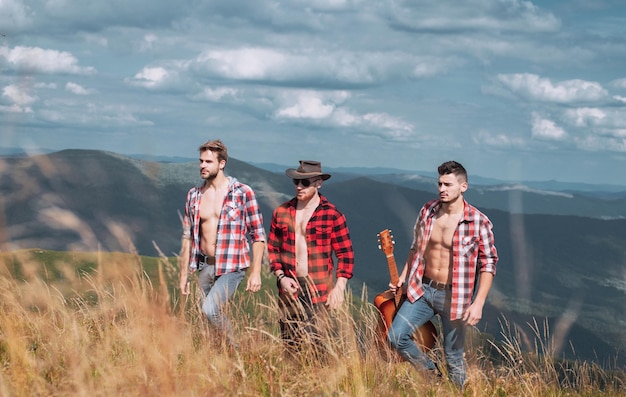 Un groupe de personnes avec guitare marchant dans les montagnes beau paysage trekking et randonnée d'activité