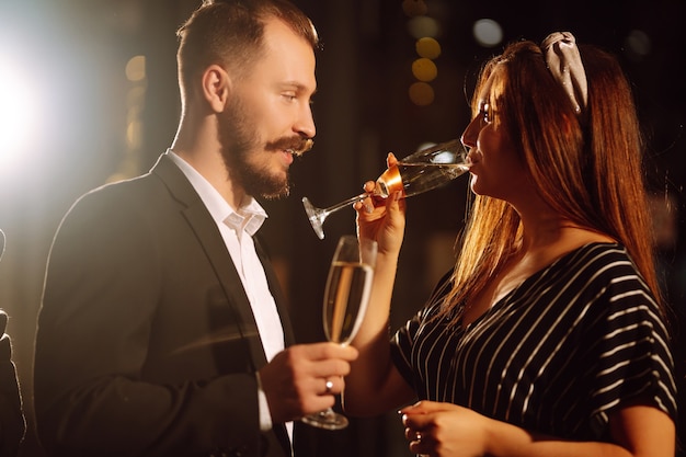 Groupe de personnes heureuses tenant des cierges magiques à la fête. Jeunes amis tinter des verres de champagne.