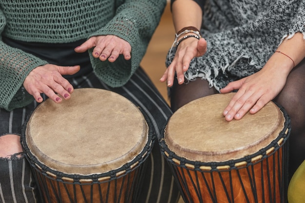 Un groupe de personnes jouant de la batterie pendant une leçon de musicothérapie jembe drum concept de batterie