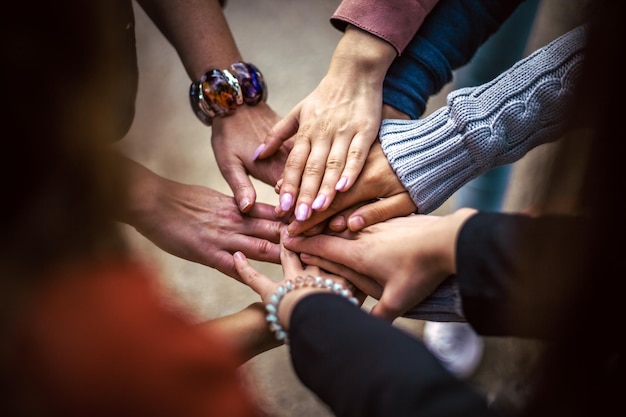 un groupe de personnes avec leurs mains jointes dont l'une a une montre sur elle